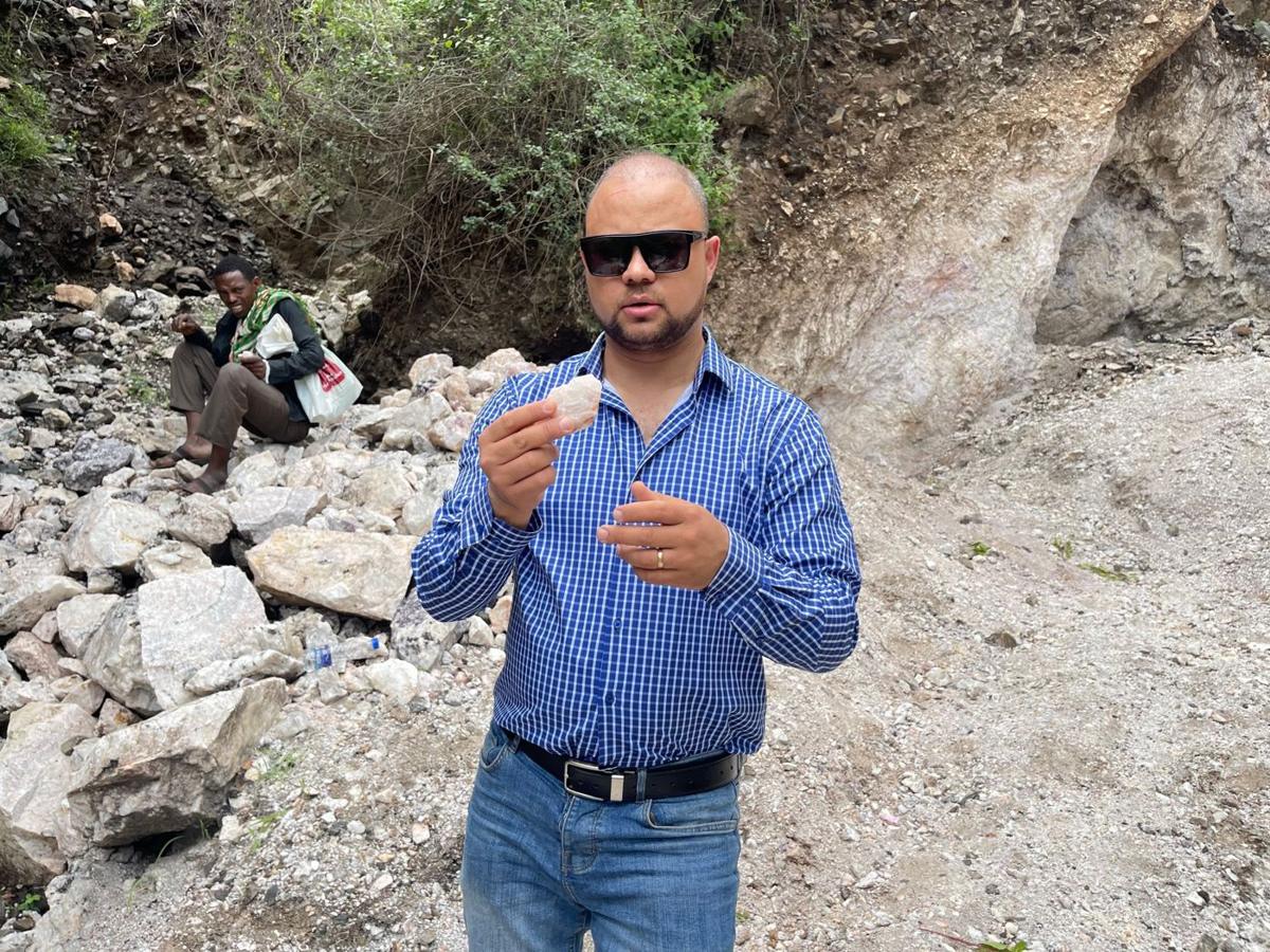 Tomas Vacilevich examining a mineral sample at a mining site in Ethiopia